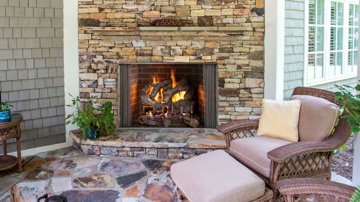 Spacious contemporary outdoor space with wood-burning fireplace in brick hearth