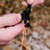 in use shot of a orange reflective cord with minimum stretch, tangle resistant, hight strength, UV protection, and the reflectiveness made from nylon and polyester being used in a campsite