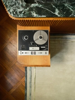 Arc rug in Spruce, corner detail beside a vintage reel-to-reel player