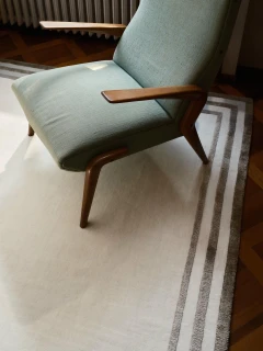Portico rug in Birch, styled vignette with an upholstered lounge chair