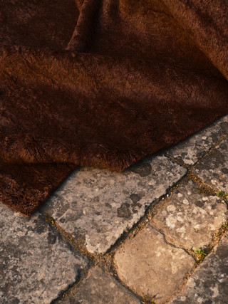 Mohair Shag rug in Carob, corner detail on stone flooring