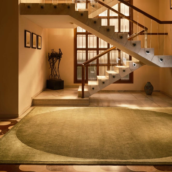 The Rug Company Doma rug, Forest colourway, styled at the base of a dramatic staircase landing