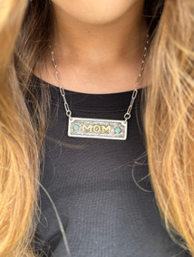 The mom pendant 
Sterling Silver with western floral hand engraving 
10k goldfill MOM overlay surrounded by 2mm round genuine turquoise on each side. 
 The mom pendant 
Sterling Silver with western floral hand engraving 
10k goldfill MOM overlay surrounded by 2mm round genuine turquoise on each side.