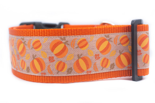 Orange dog collar with a repeating pattern of orange and yellow pumpkins on a burlap patterned background.