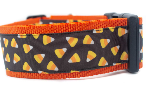 A black and orange dog collar with a pattern of yellow and orange candy corn on a black background. 