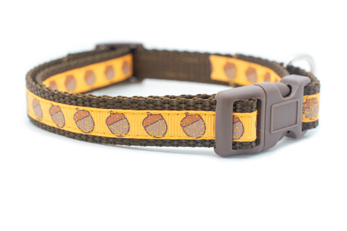 A brown dog collar with a pale orange and brown acorn pattern.
