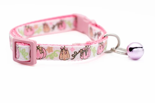 Pink dog collar featuring a white ribbon trim printed with sparkly pink pumpkins, peach pumpkins and vines.