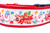 A red dog collar with a design includes a red airplane carrying presents, snowflakes, candy canes, and colorful ornaments.