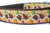 A brown dog collar with a pale orange background and a pattern of turkeys, pilgrim hats, pumpkins, corn and leaves.