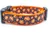 Smiling jack o' lanterns on a black polka dot background.  1 inch wide orange nylon.