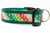 Holiday dog collar featuring a red and green gradient ribbon pattern with white snowflakes stitched onto dark green webbing