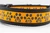 Halloween dog collar with glittery jack o lantern paws on orange background.