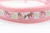 Pink dog collar featuring a white ribbon trim printed with sparkly pink pumpkins, peach pumpkins and vines.