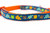 Multicolored fall leaves in brown, orange, lime and blue with swirls and dark blue background on an orange nylon.