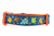 Multicolored fall leaves in brown, orange, lime and blue with swirls and dark blue background on an orange nylon.