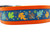 Multicolored fall leaves in brown, orange, lime and blue with swirls and dark blue background on an orange nylon.