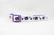 A white cat collar with a purple adjustable safety buckle and purple nylon. The collar has a repeating pattern of black cats with purple bows and purple paw prints.