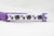 A white cat collar with a purple adjustable safety buckle and purple nylon. The collar has a repeating pattern of black cats with purple bows and purple paw prints.