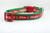 A green and red Christmas-themed dog collar. The collar has a red ribbon with the words "Naughty" and "Nice" in white. 