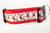 Red dog collar with a repeating pattern of reindeer wearing Santa hats. 