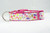 A pink dog collar with a white background and a floral pattern featuring leaves and flowers.