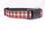 A black dog collar with a red and white plaid ribbon with gold glitter accents.