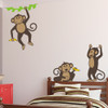 Vinyl wall decals of three monkeys holding bananas and playing .