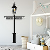 The Gas Lamp wall decal with customizable signs on a bedroom wall in black vinyl.