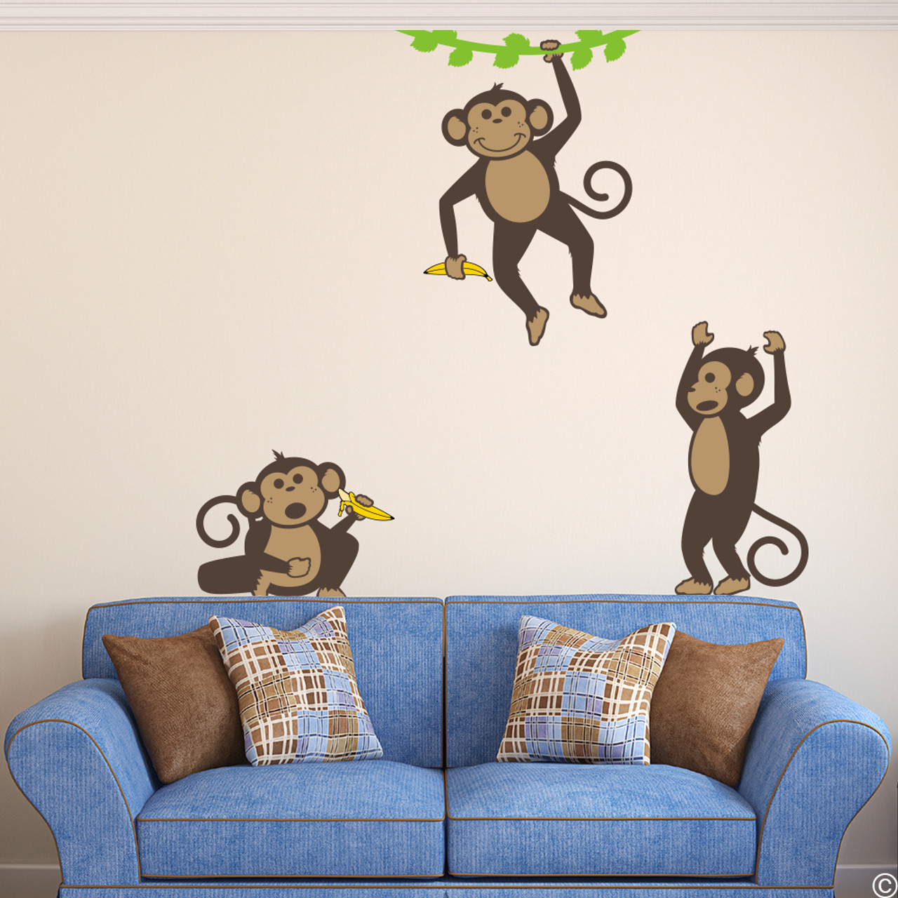 Vinyl wall decals of three monkeys holding bananas and playing .