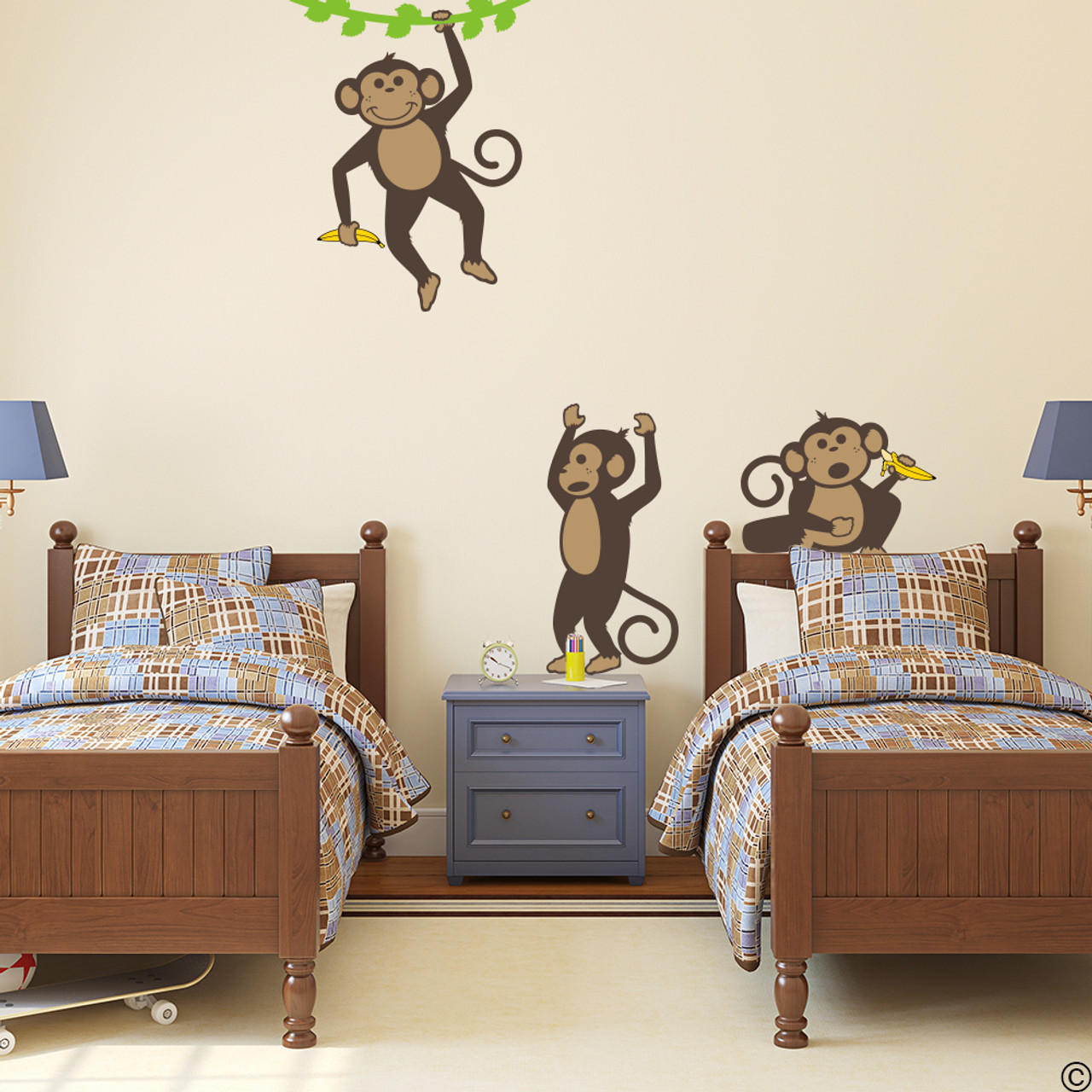 Vinyl wall decals of three monkeys holding bananas and playing .