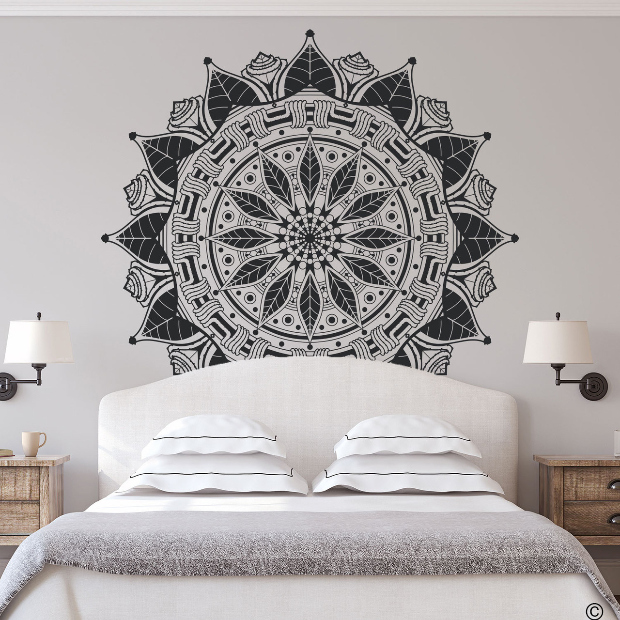 The Francis mandala wall decal shown here above a bed in the black vinyl color.