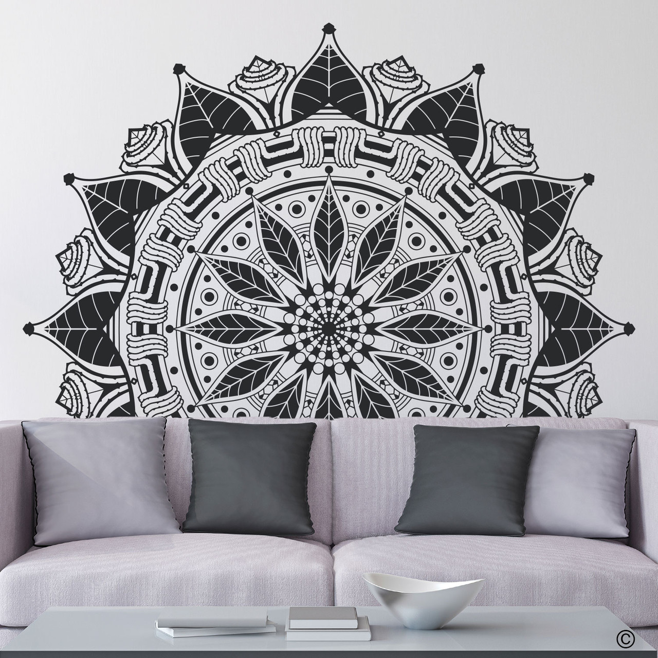 The Francis mandala wall decal shown here behind a couch in the black vinyl color.
