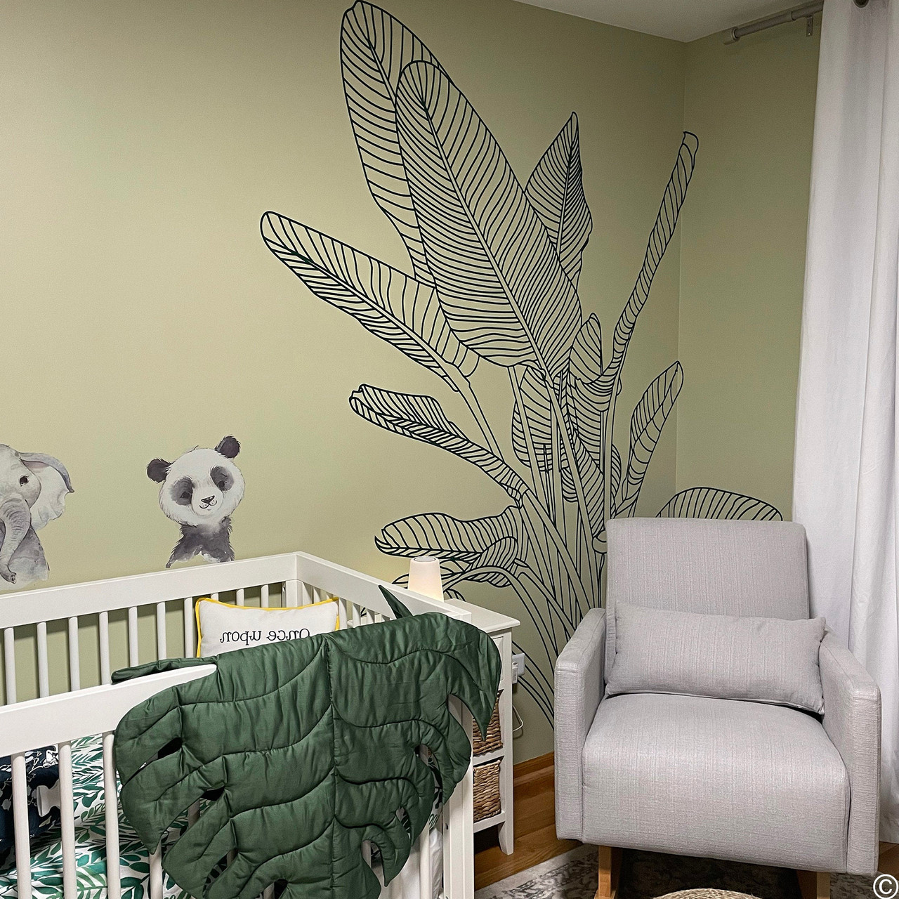 Customer photo of the Bird of Paradise wall decal in dark blue vinyl color in a nursery room.