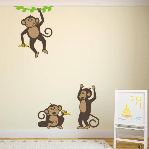 Vinyl wall decals of three monkeys holding bananas and playing .