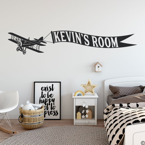 Biplane wall decal with customizable name banner on a kids bedroom wall in black vinyl. 