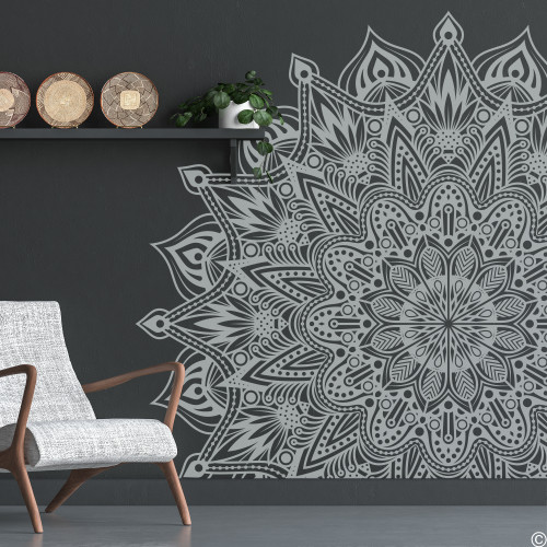 The image presents a sophisticated and contemporary living space featuring a large, intricately designed light grey mandala wall decal named "Shyla" on a dark grey wall. The mandala's detailed and symmetrical patterns stand out strikingly against the dark background, creating a dramatic focal point. To the left, a modern chair with light grey upholstery and wooden armrests adds a touch of comfort and style. Above the chair, a simple black shelf holds a potted plant and three decorative plates, introducing subtle elements of nature and culture into the room. The floor is a polished dark surface, complementing the overall sleek and modern aesthetic. The decor exudes a calm and elegant ambiance, perfect for a tranquil living area. The image presents a sophisticated and contemporary living space featuring a large, intricately designed light grey mandala wall decal named "Shyla" on a dark grey wall. The mandala's detailed and symmetrical patterns stand out strikingly against the dark background, creating a dramatic focal point. To the left, a modern chair with light grey upholstery and wooden armrests adds a touch of comfort and style. Above the chair, a simple black shelf holds a potted plant and three decorative plates, introducing subtle elements of nature and culture into the room. The floor is a polished dark surface, complementing the overall sleek and modern aesthetic. The decor exudes a calm and elegant ambiance, perfect for a tranquil living area.