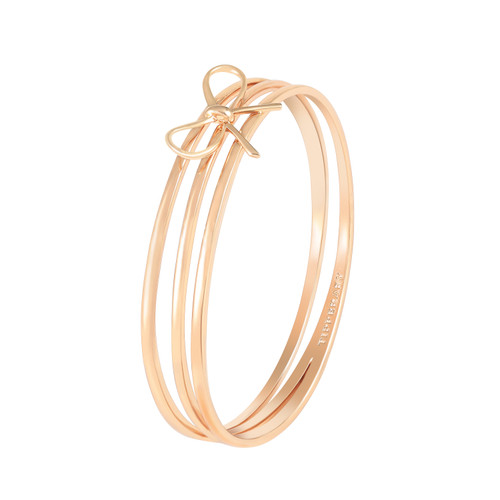 Gold-tone triple-band bangle bracelet with a polished bow detail connecting the three bands. Gold-tone triple-band bangle bracelet with a polished bow detail connecting the three bands.