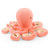 A soft, plush toy shaped like a salmon-colored octopus. The octopus is positioned in a three-quarter view, looking to the right. Its tentacles are curled, showing their textured, cream-colored underside.