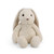 A close-up side view of a soft, cream-colored plush bunny toy with long floppy ears and a round, fluffy body.