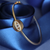 Gold Evil Eye Star Burst Bangle displayed on navy blue ribbon – lifestyle jewellery photo