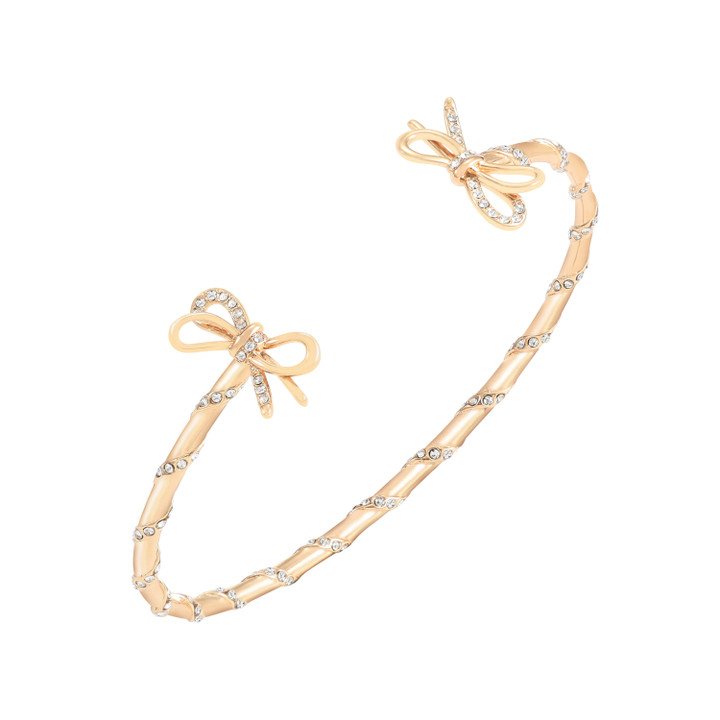 Gold-tone wrap bangle bracelet with a twisted design and crystal-studded bow accents at both ends.