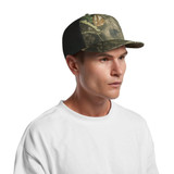 A cap featuring a mesh back and a contrast camo pattern in greens and browns, worn by a model.