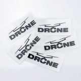 Five black drone-themed stickers on clear backing, featuring the word "DRONE" and outlined designs of drones.