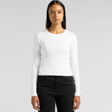 A woman wearing a white long-sleeve tee paired with black jeans, featuring a logo on the side.