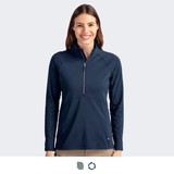 A woman is wearing a navy blue half-zip pullover with a sleek design and a small logo.