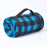 A rolled Klondike fleece blanket in blue and black checkered pattern, secured with a black strap. A rolled Klondike fleece blanket in blue and black checkered pattern, secured with a black strap.