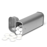 A silver tin filled with round white mints, with some mints scattered beside it. The tin has a lid partially open. A silver tin filled with round white mints, with some mints scattered beside it. The tin has a lid partially open.