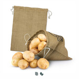A large jute produce bag in beige, filled with fresh potatoes, with another empty bag in the background. A large jute produce bag in beige, filled with fresh potatoes, with another empty bag in the background.