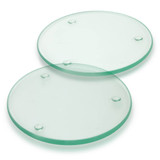 Two round glass coasters in a light green colour, featuring small raised dots for stability. Two round glass coasters in a light green colour, featuring small raised dots for stability.