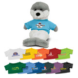 A grey and white seal plush toy wearing a blue T-shirt, surrounded by various colourful miniature T-shirts.